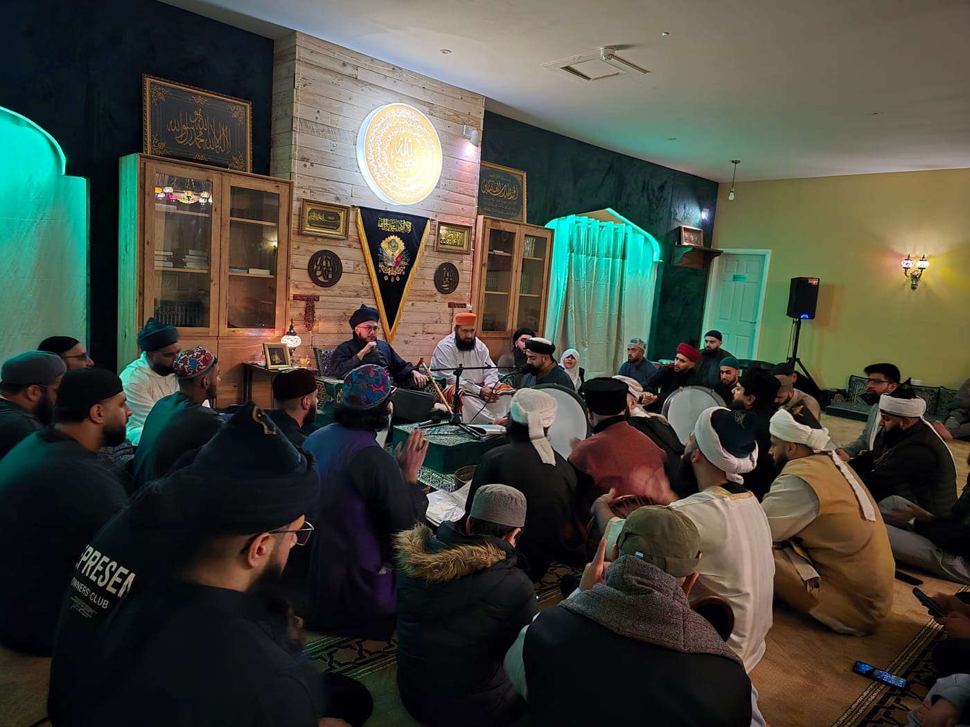 Murids playing the daf around the shaykhs during a Hadrah.