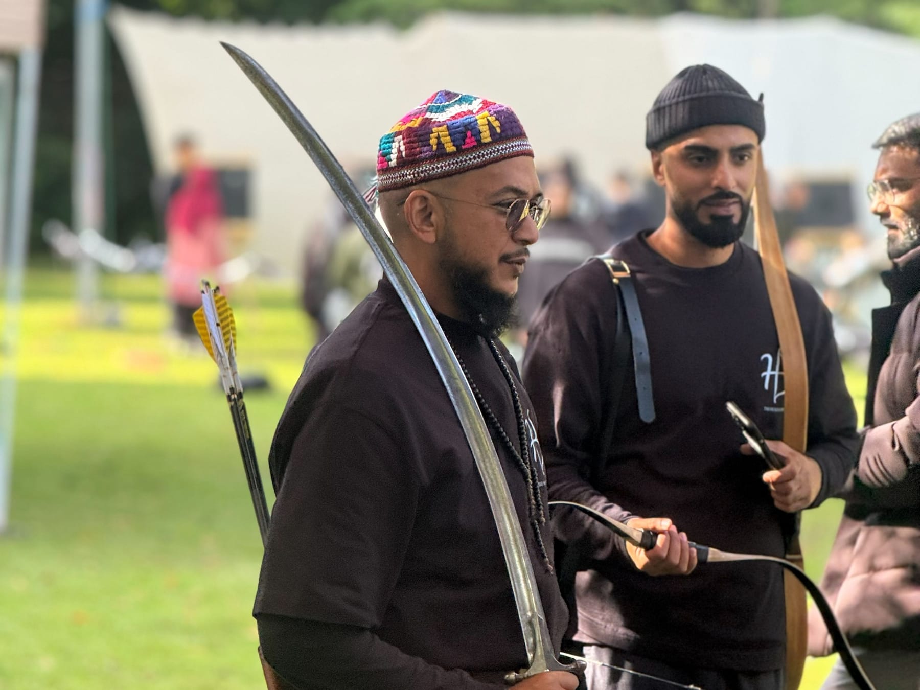 An archer holding a sword and a traditional bow.