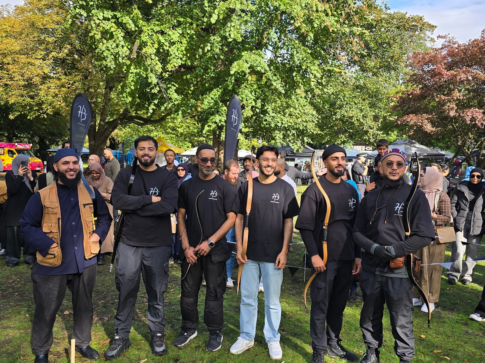 The archers together at an outdoor event, bows in hand.