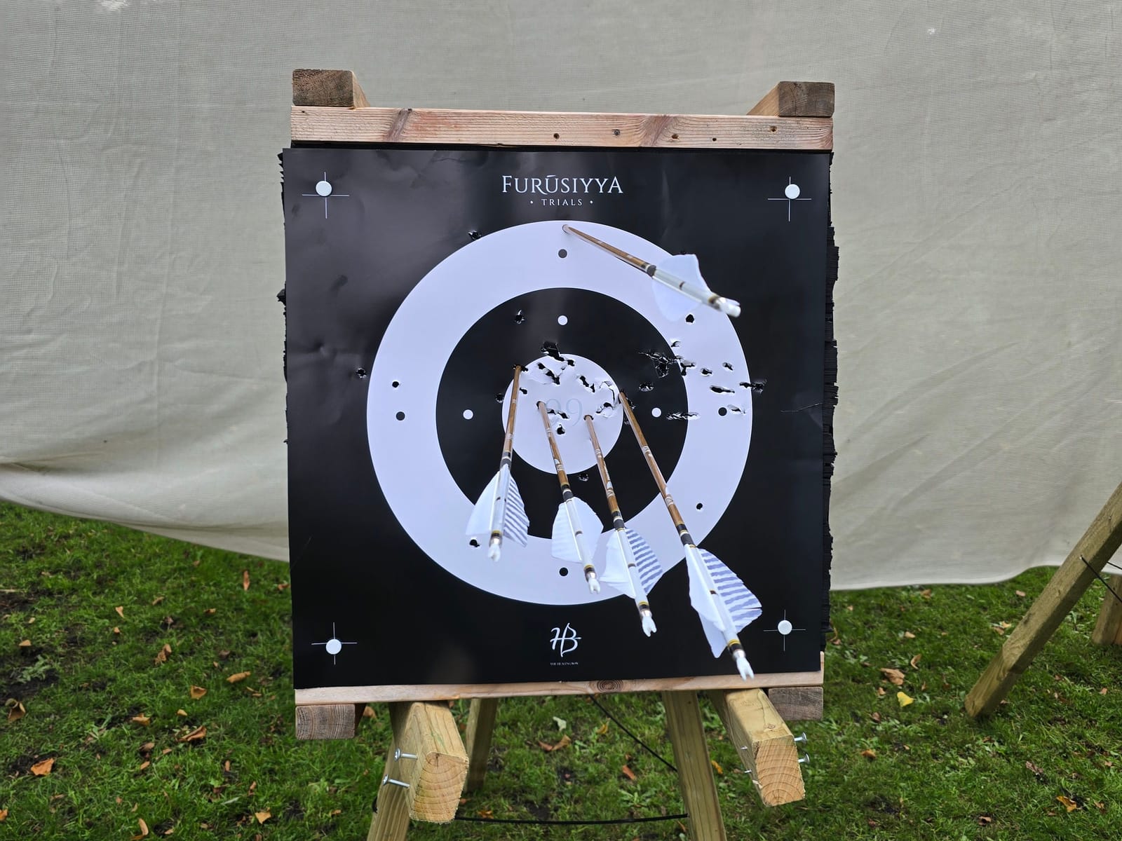 A target on a stand with arrows grouped near the centre.