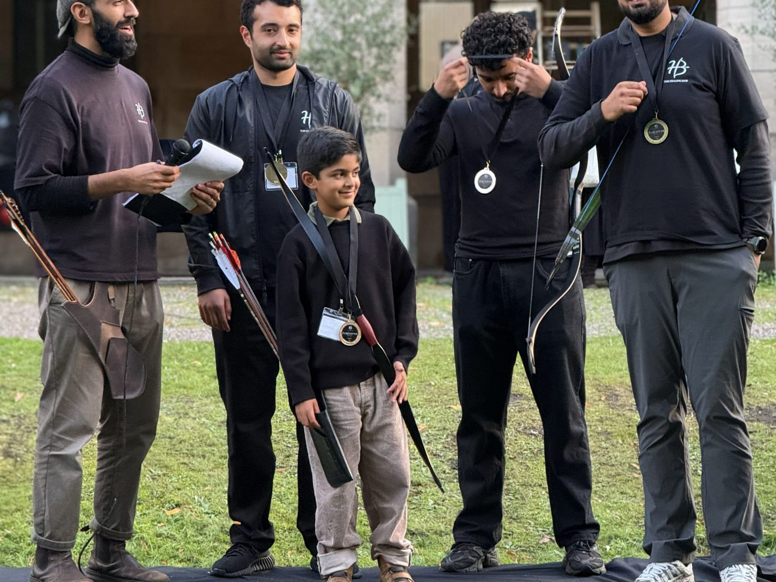 An instructor presenting a young archer at an event.