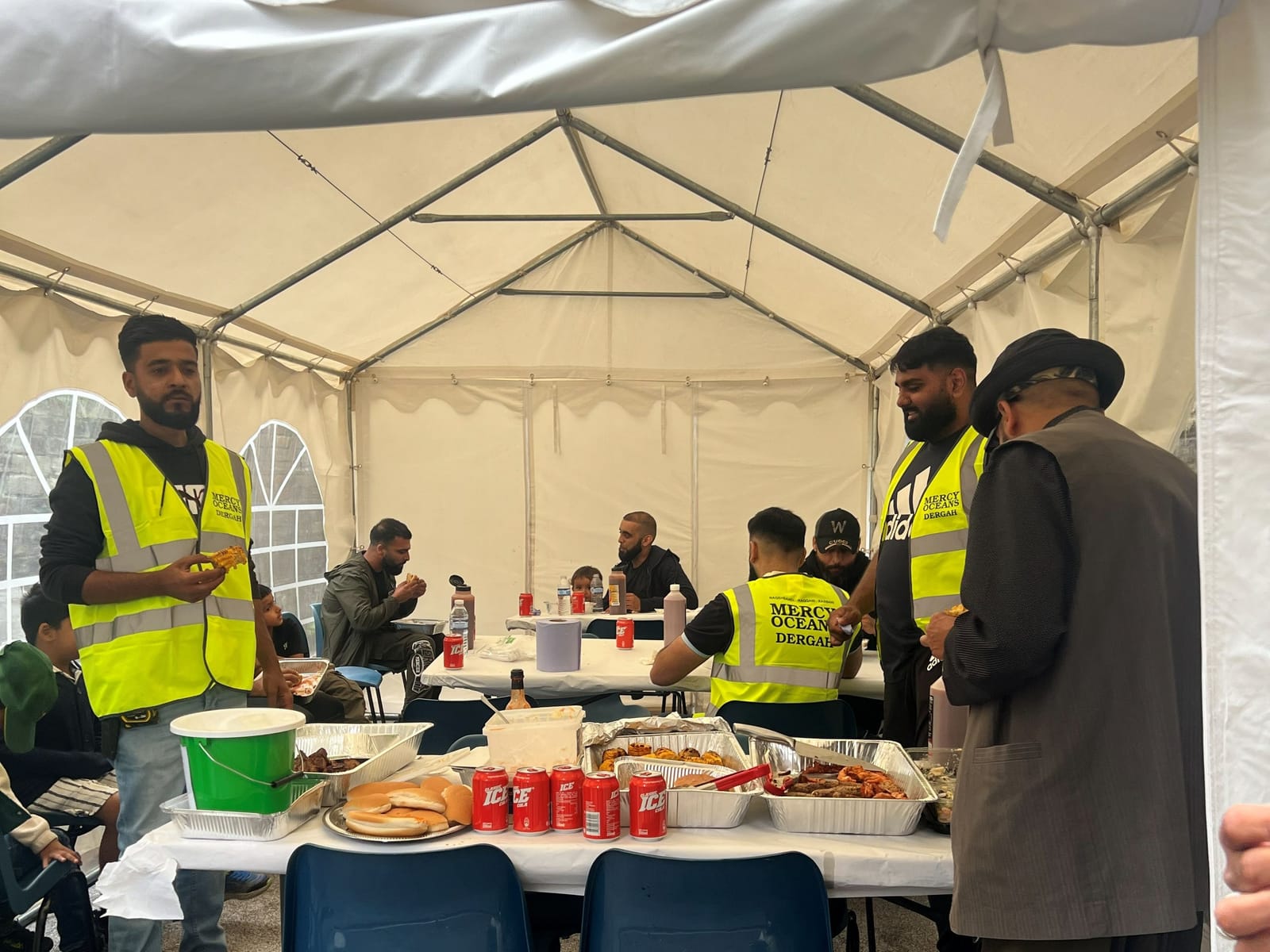 Volunteers serving food in the marquee.